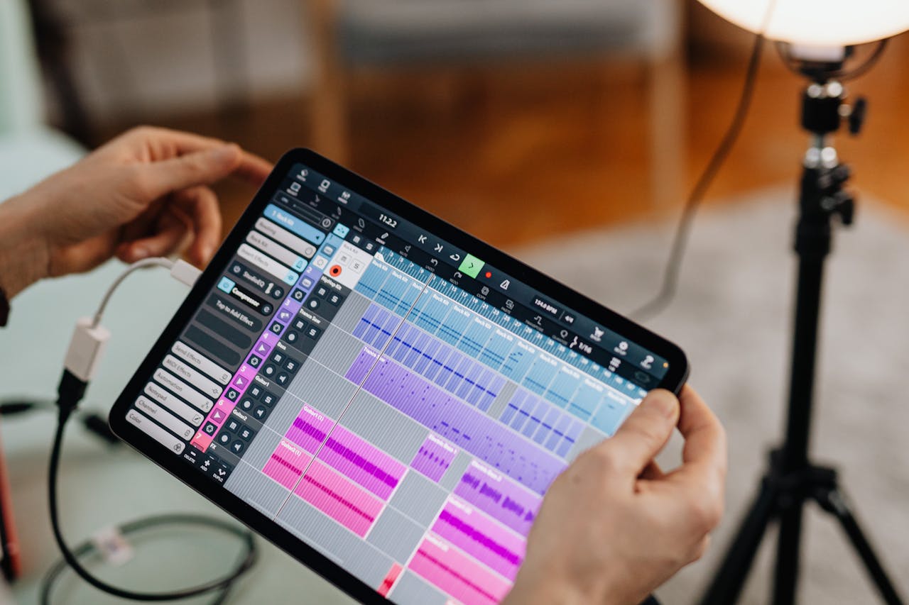 Close-up of hands holding a tablet showing music software, perfect for audio production themes.